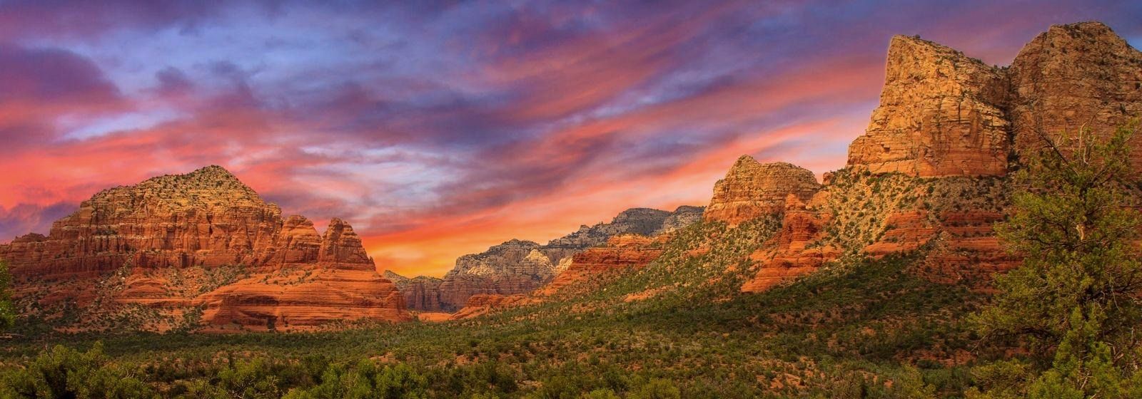 Sedona red rock formations glowing under a sunset sky